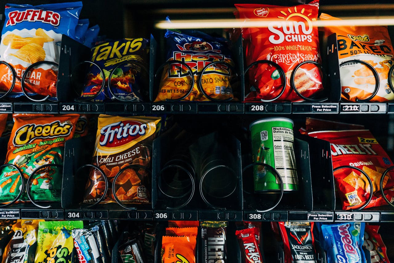 Close-up of a vending machine filled with popular snack brands like Cheetos and Fritos.